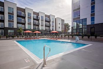 A large swimming pool in front of apartment buildings.